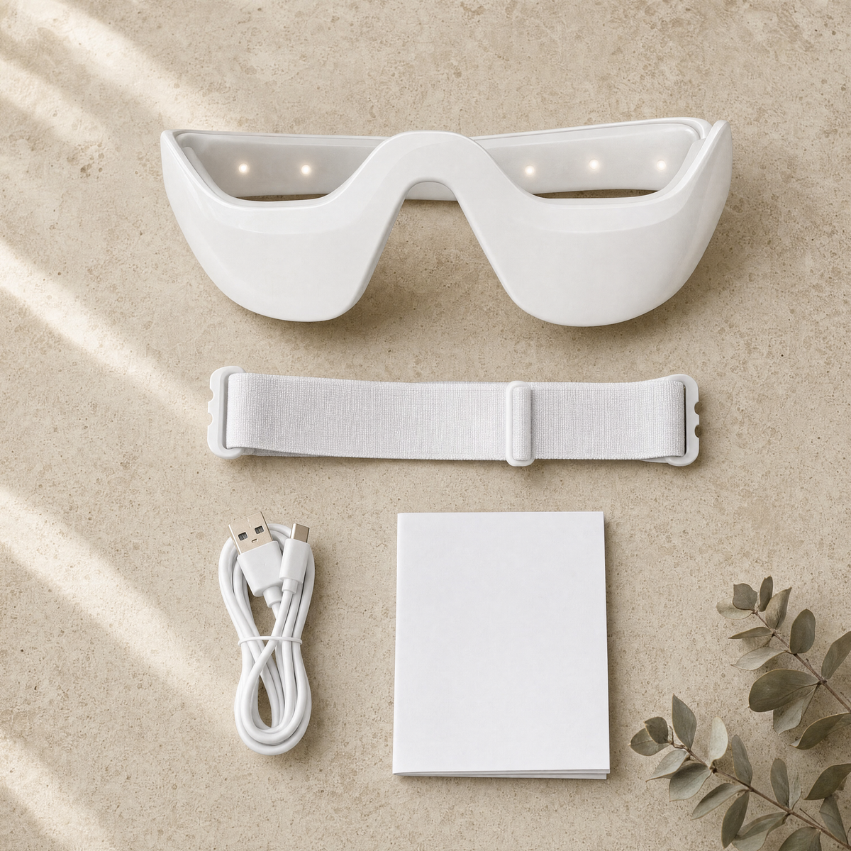 Eye Contour Massager with its adjustable strap, USB-C cable and instruction card